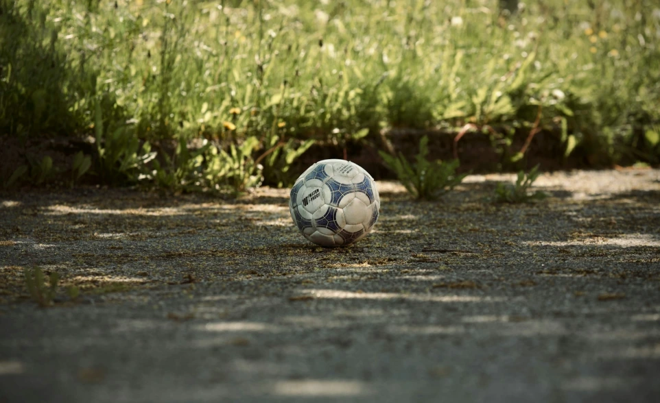 a soccer ball sitting in the middle of the road